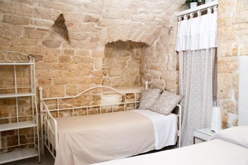 a bedroom with two beds and a stone wall at Relais del Marchese in Turi