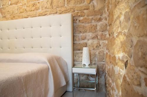 a bedroom with a brick wall and a bed and a lamp at Relais del Marchese in Turi