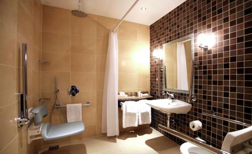 uma casa de banho com um lavatório, um WC e um chuveiro em DoubleTree by Hilton Dunblane Hydro Hotel em Dunblane