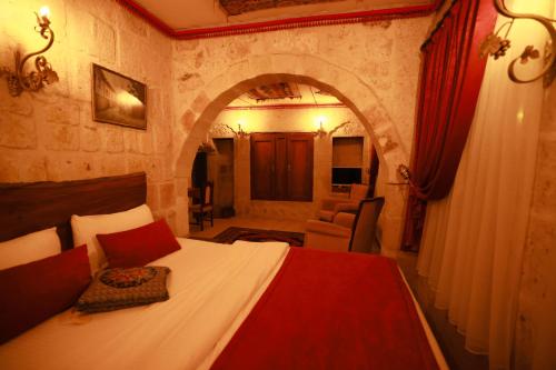 a bedroom with a bed in a room with an arch at Cappadocia Nar Cave House & Swimming Pool in Nevsehir