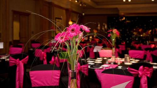 a room with pink tables and chairs with pink flowers at DoubleTree by Hilton Dunblane Hydro Hotel in Dunblane