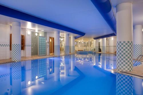 a swimming pool with blue lighting in a building at Hilton Nottingham Hotel in Nottingham
