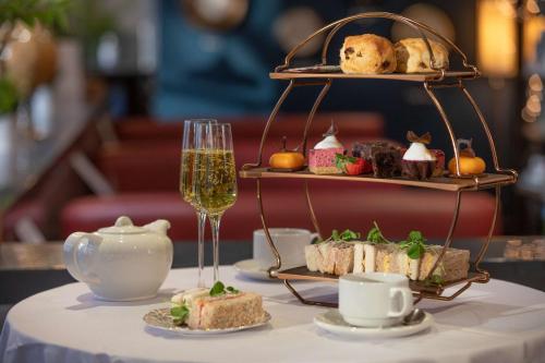 a table with a plate of food and a glass of wine at Hilton Nottingham Hotel in Nottingham
