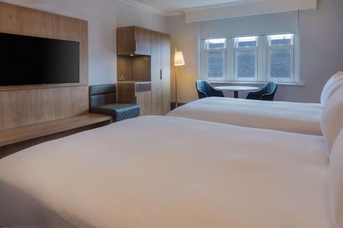 a hotel room with two beds and a flat screen tv at Hilton Nottingham Hotel in Nottingham