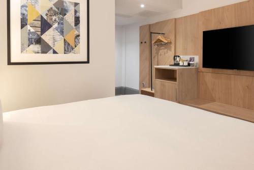 a hotel room with a bed and a flat screen tv at Hilton Nottingham Hotel in Nottingham
