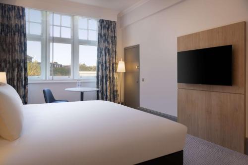 a hotel room with a bed and a flat screen tv at Hilton Nottingham Hotel in Nottingham