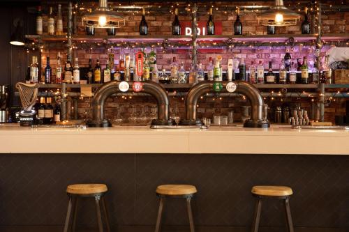 a bar with two stools in front of a bar at Hilton Nottingham Hotel in Nottingham