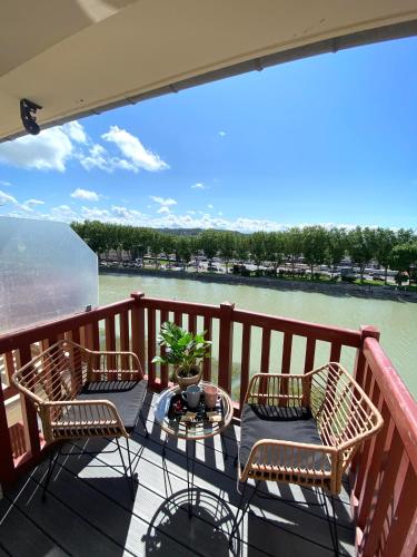 a balcony with two chairs and a table with a view of a river at Splendide Studio avec balcon - Trouville centre in Trouville-sur-Mer