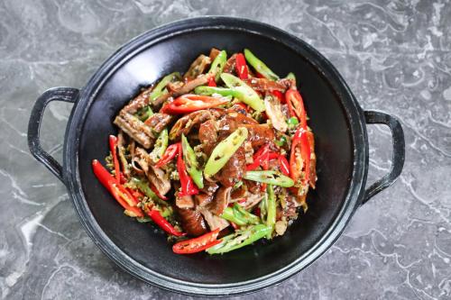 a pan filled with meat and vegetables on a table at Holiday Inn Fuyang by IHG in Fuyang