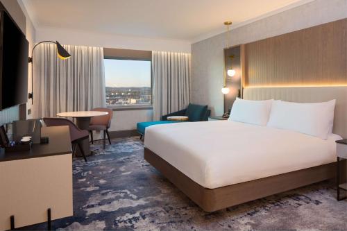 um quarto de hotel com uma cama grande e uma mesa em Hilton Glasgow em Glasgow