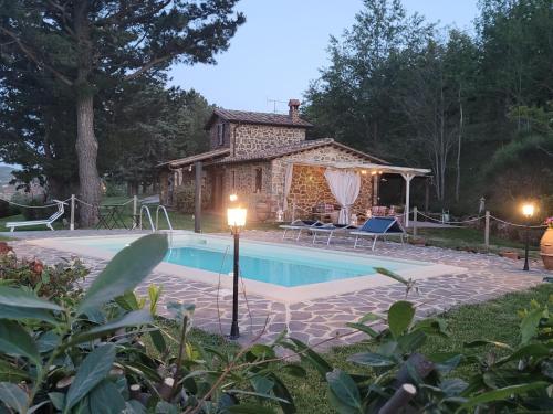 une piscine en face d'une maison avec un bâtiment dans l'établissement Agriturismo "Apparitoio", à Montelaterone