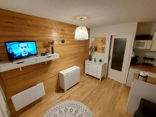 a living room with a flat screen tv on a wooden wall at Joli studio 4 couchages aux pieds des pistes in Puy-Saint-Vincent