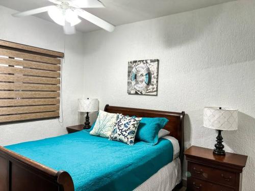 Schlafzimmer mit einem Bett mit blauer Bettwäsche und einem Deckenventilator in der Unterkunft Ocean Front PRINCESA Resort D108-Sandy Beach-Ground Floor-HUGE in Puerto Peñasco