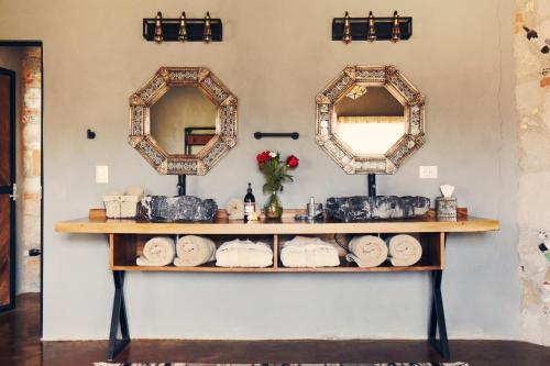 a bathroom with two mirrors and a shelf with towels at Casa Pavo Real en el Viñedo El Pavo Real del Campo in San Miguel de Allende