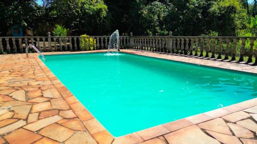 - une piscine avec une fontaine dans la cour dans l'établissement SITIO DO BIRA, à São Joaquim de Bicas