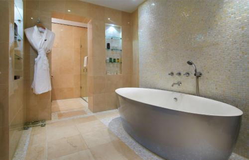 uma casa de banho com uma banheira grande e um chuveiro em Hilton London Syon Park em Brentford