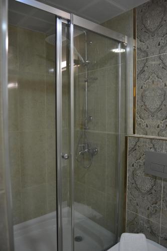 a shower with a glass door in a bathroom at Admiral Hotel in Kizkalesi