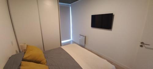 Habitación pequeña con cama y TV de pantalla plana. en MyA, en Monte Hermoso