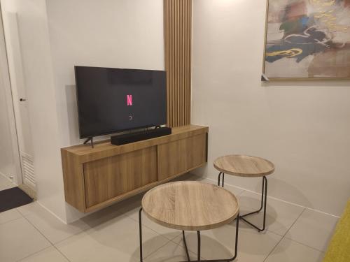a tv sitting on a stand with two stools at The Zen Suites at Matina Enclaves in Davao City
