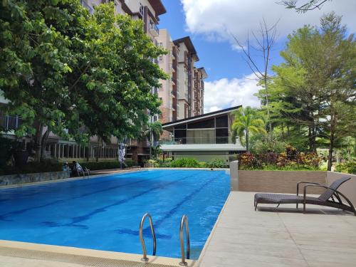 a large swimming pool with two chairs next to a building at The Zen Suites at Matina Enclaves in Davao City