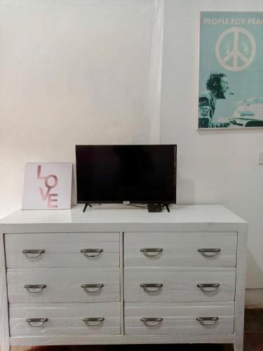 a white dresser with a television on top of it at Casa Yoly Hostel Granada in Granada