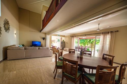 a living room with a table and a couch at Anse Boudin Chalets & Villa in Praslin
