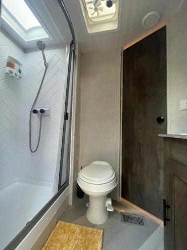 a bathroom with a toilet and a shower at Your Personal 'Glamp' Site! AC - BBQ - Fast WiFi in DeLand