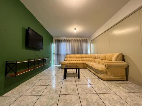sala de estar con sofá y TV de pantalla plana en Pousada VSC, en São Francisco do Sul