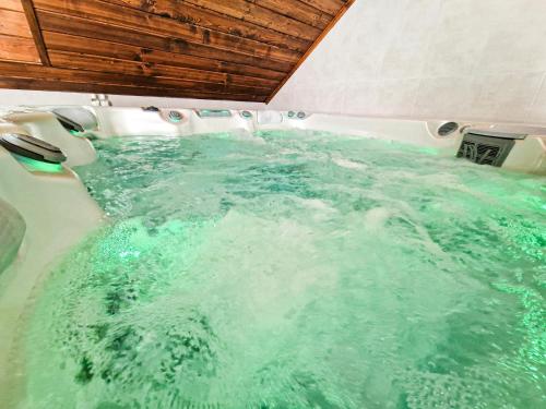 eine Whirlpool-Badewanne in einem Boot mit grünem Wasser in der Unterkunft GraVelo - Apartament Jacuzzi in Bartkowa-Posadowa