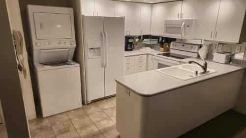una cocina con electrodomésticos blancos y armarios blancos en Club Lakeridge, en Reno