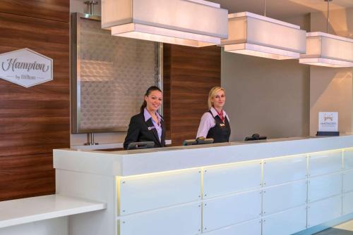 two women standing in front of a mirror at Hampton by Hilton Luton Airport in Luton