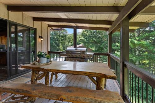 a wooden deck with a picnic table and a grill at Banner Barn in Banner Elk