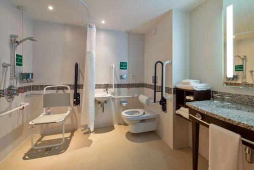 a bathroom with a toilet and a shower and a sink at Hampton by Hilton Luton Airport in Luton