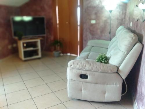 a white couch sitting in a living room with a tv at Villino Ulivo in Le Casette