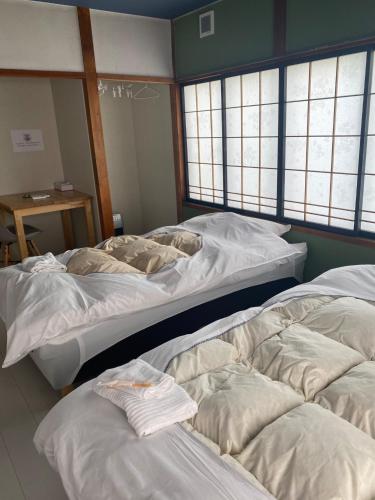 two large beds in a room with windows at guest house goose - Vacation STAY 21037v in Hirosaki