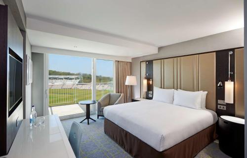 サウサンプトンにあるHilton Southampton - Utilita Bowlのベッドと大きな窓が備わるホテルルームです。