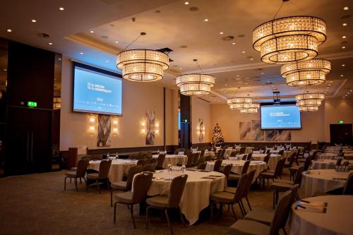 a banquet hall with tables and chairs and chandeliers at Hilton Southampton - Utilita Bowl in Southampton