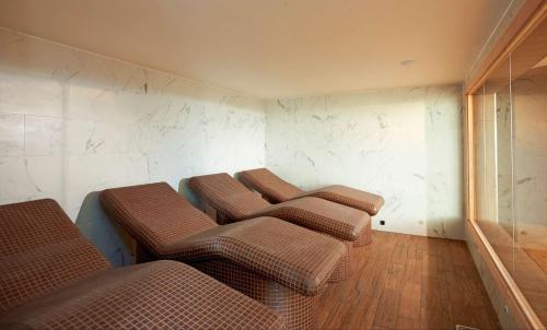 four brown chairs in a room with marble walls at Hilton Southampton - Utilita Bowl in Southampton