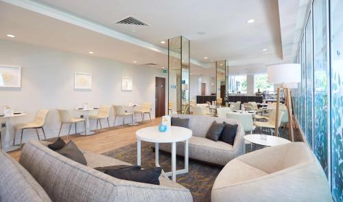 a hotel lobby with couches and tables and chairs at Hilton Southampton - Utilita Bowl in Southampton