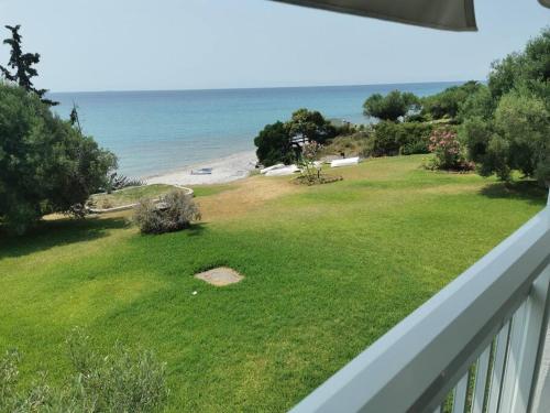 a view of the beach from the balcony of a house at Απέραντο γαλάζιο Le grand blue in Mola Kalyva
