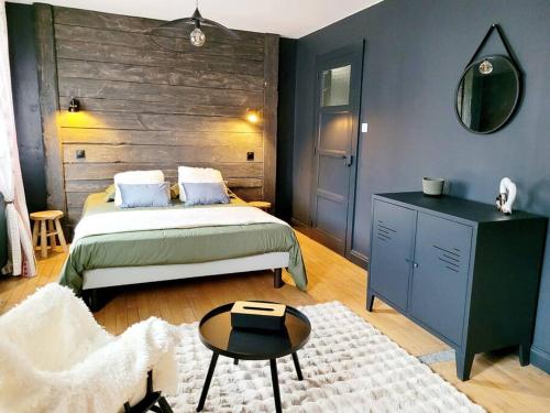 una camera con letto, tavolo e specchio di Maison Les Planches a Gérardmer