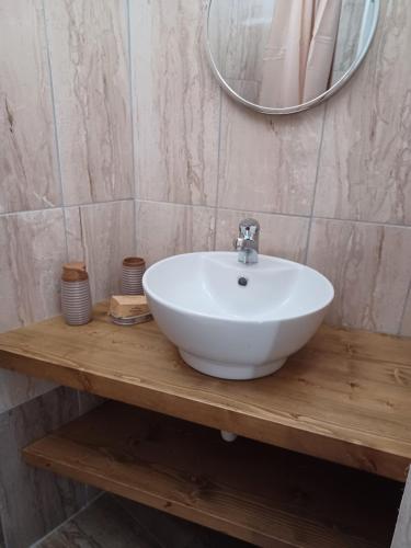 a bathroom with a white sink and a mirror at Pension Annoula in Archangelos