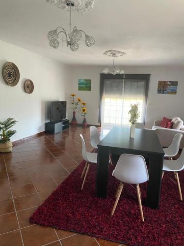 a living room with a black table and white chairs at PESO RIVER HOUSE in Melgaço