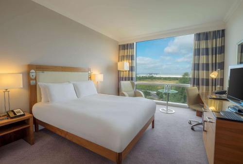 a hotel room with a bed and a large window at Hilton Reading in Reading