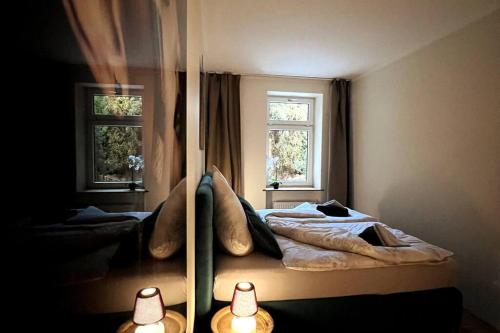 um quarto com uma cama e duas janelas em 4YOUnic: Designer-Wohnung *Nähe Zentrum*kostenloser Parkplatz*Boxspringbett*55Zoll OLED*WLAN em Leipzig