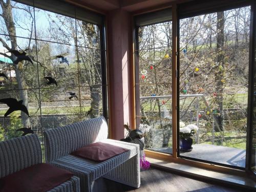 a living room with a couch and a large window at Ferienwohnung im Naturgarten in Chemnitz