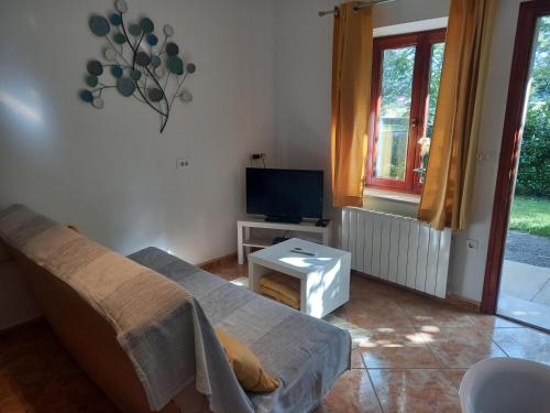 a living room with a couch and a tv at Apartman Dani in Dražice