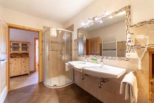 y baño con lavabo, ducha y espejo. en Huberhof en Villandro
