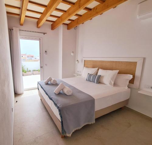 a bedroom with a bed and a large window at Waki Conscious Hotel in Ciutadella