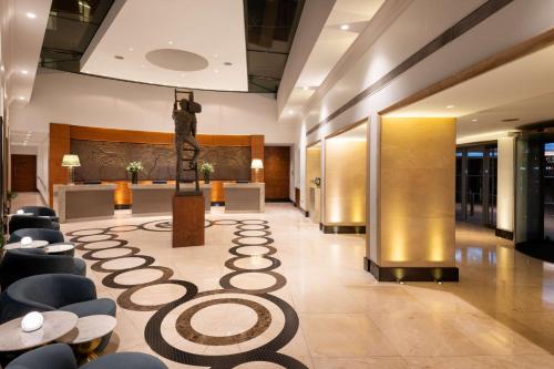 a lobby with chairs and a statue in the middle at Conrad London St James in London